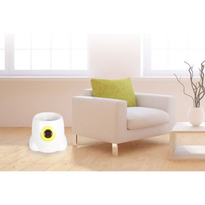 White and yellow device on a wooden floor next to a beige armchair with a green pillow.