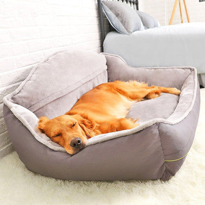 Dog lying on a grey pet bed in a cozy room.