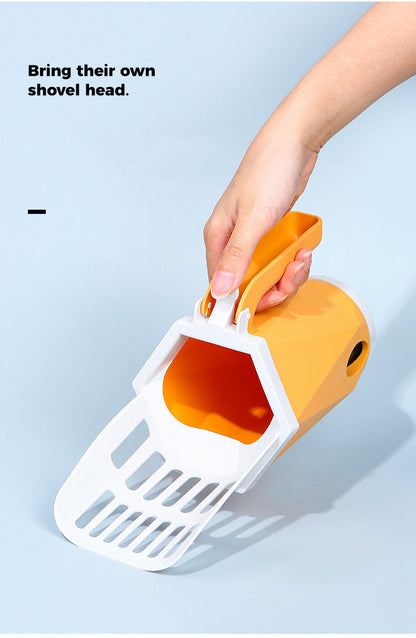 Hand holding a white and orange pet litter scoop against a light blue background