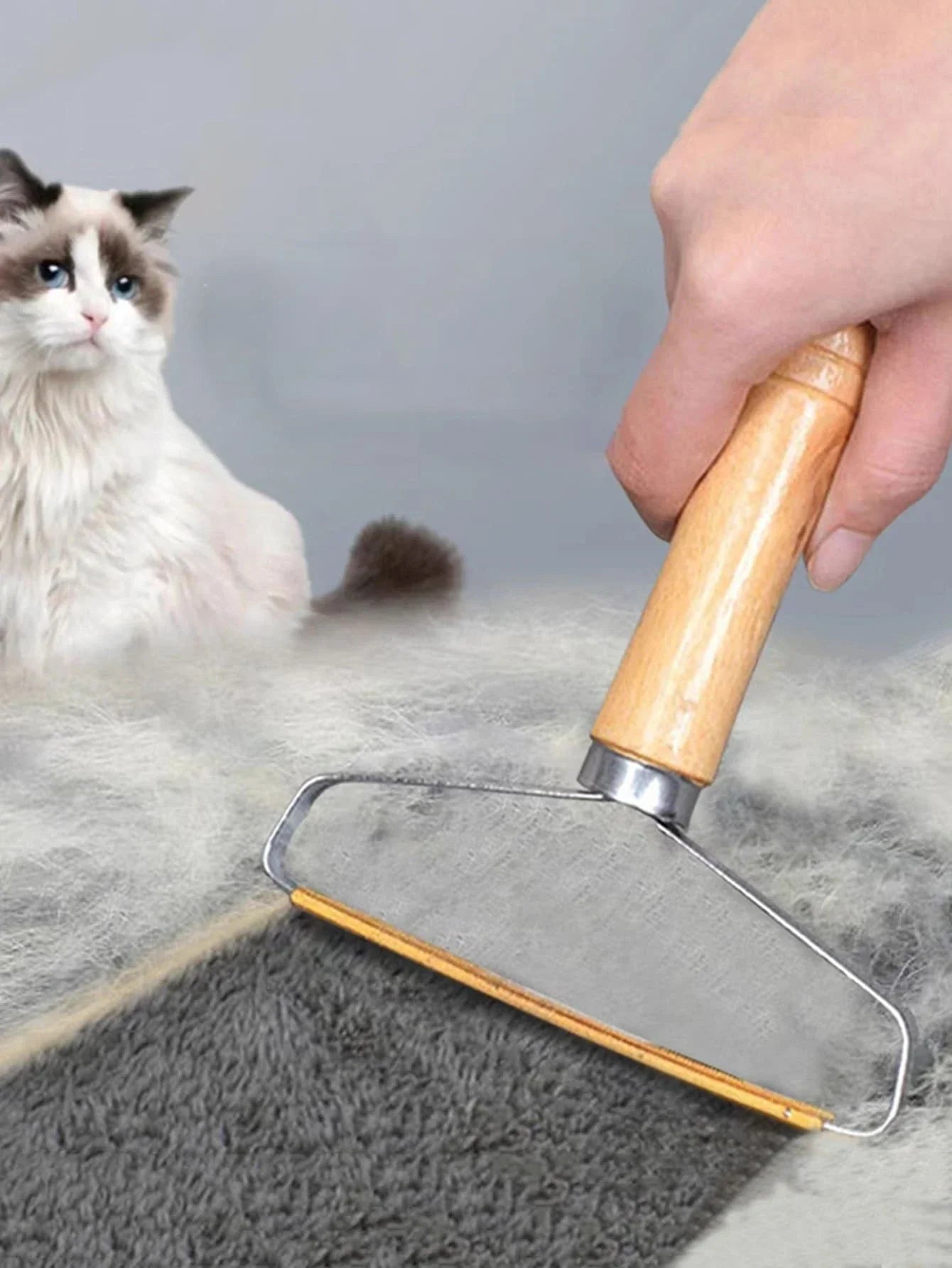 Person using a pet hair removal tool on furniture with a grey background