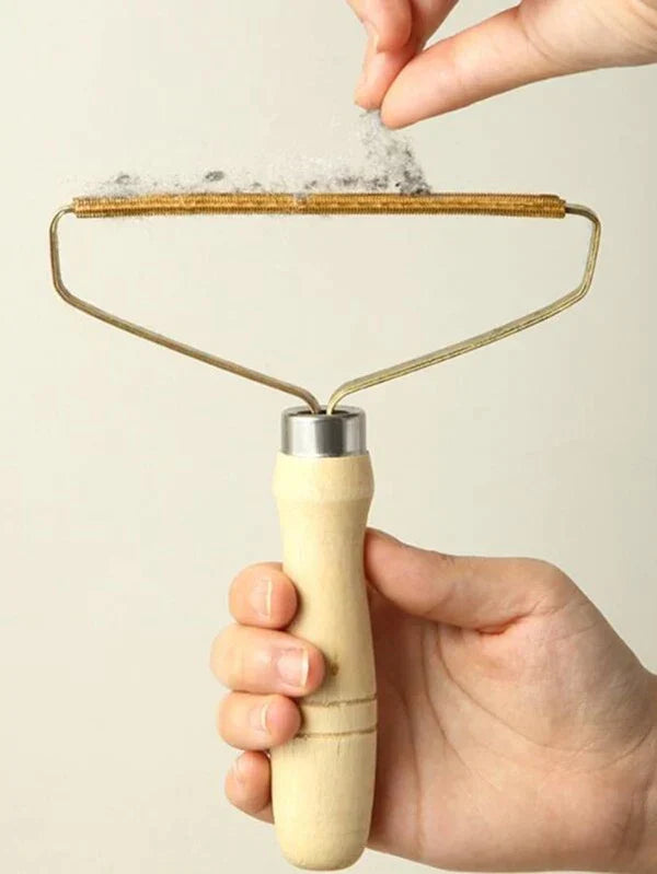 Hand holding a wooden roller with a metal mesh over a light background