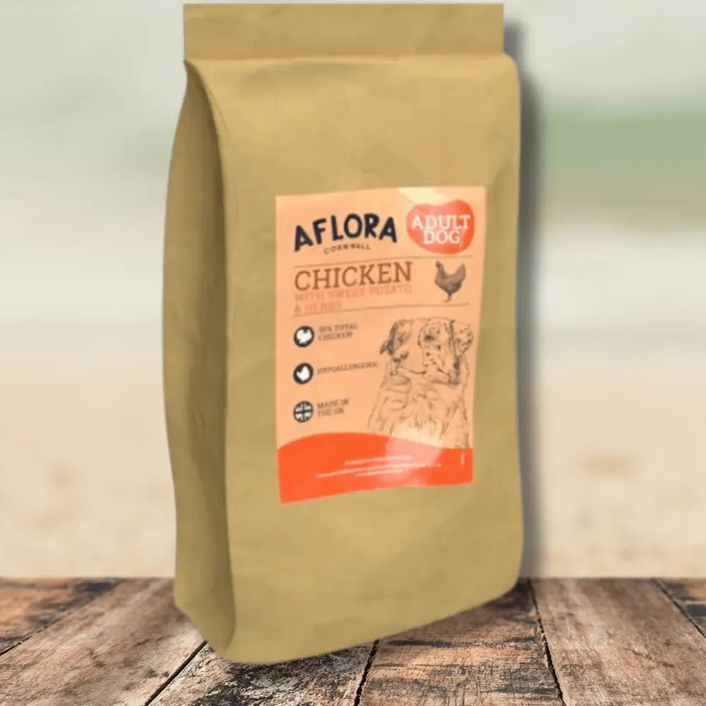 Bag of Aflora chicken dog food on a wooden surface with a blurred background