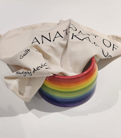 Rainbow striped container with a beige cloth featuring text on a white background