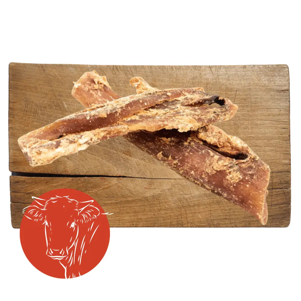 Dog treats on a wooden board with a red circle featuring a dog illustration.