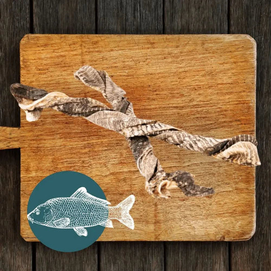 Wooden cutting board with fish skin and a small illustration of a fish on a wooden background