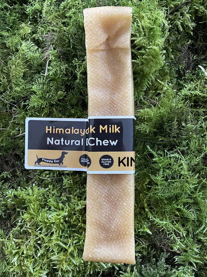King size dog chew treat with 'Himalayan Milk Natural Chew' label on a green moss background