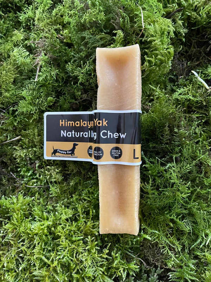 Dog chew treat with 'Himalayan Milk Naturally Chew' label on a green moss background