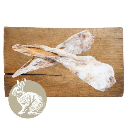 Two rabbit carcasses on a wooden cutting board with a small inset image of a rabbit.