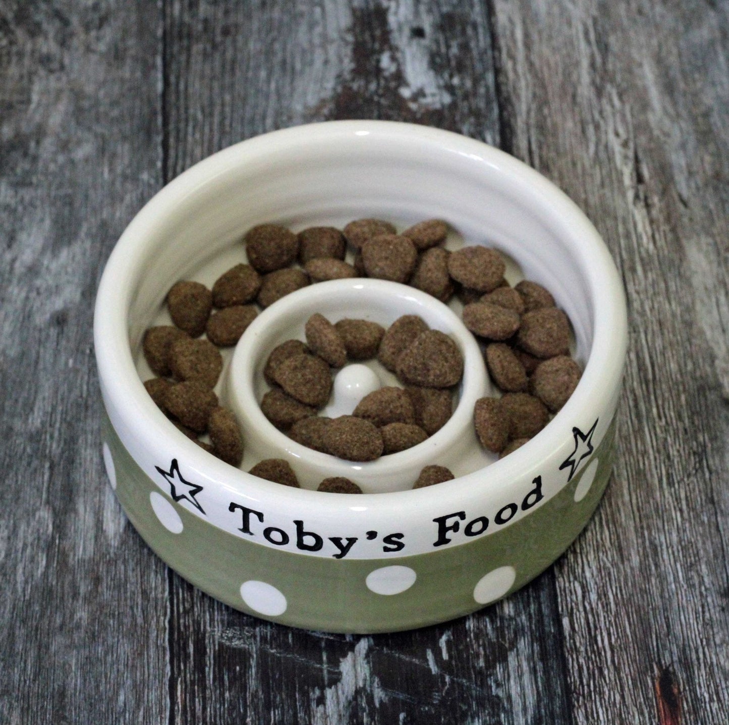 Pet food bowl with 'Toby's Food' label on a wooden surface
