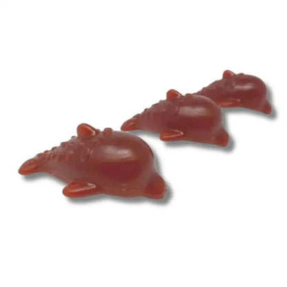 Three red gummy alligator candies on a white background