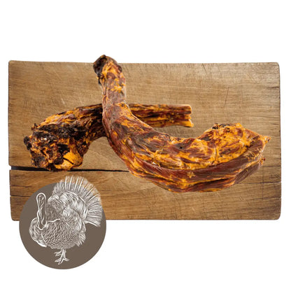 Wooden cutting board with cured meat and a small illustration of a turkey on a white background