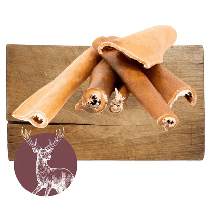 Dog chew toys on a wooden block with a deer illustration in the corner.
