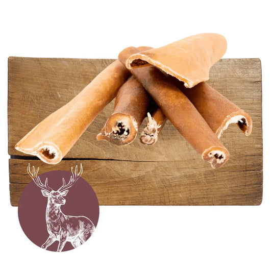 Dog chew toys on a wooden block with a deer illustration in the corner.