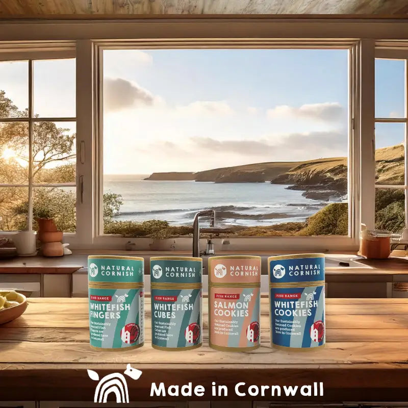 Cans of Natural Cornish food products on a kitchen counter with a scenic window view.